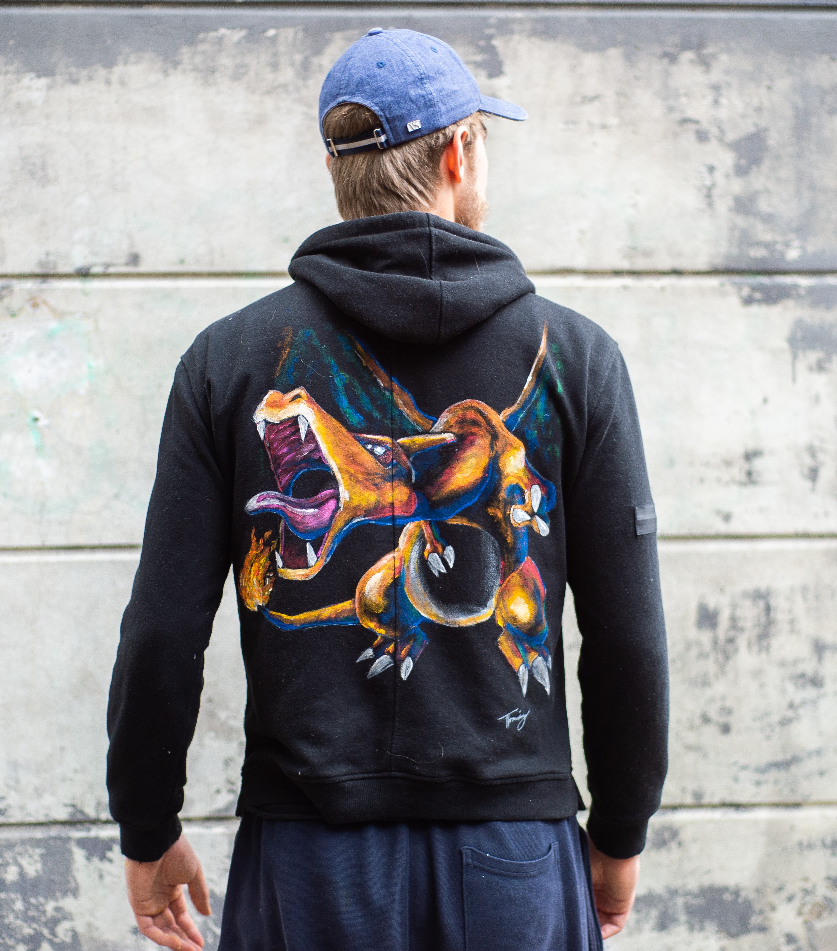 picture of a hoodie with a painting of charizard, a fire dragon